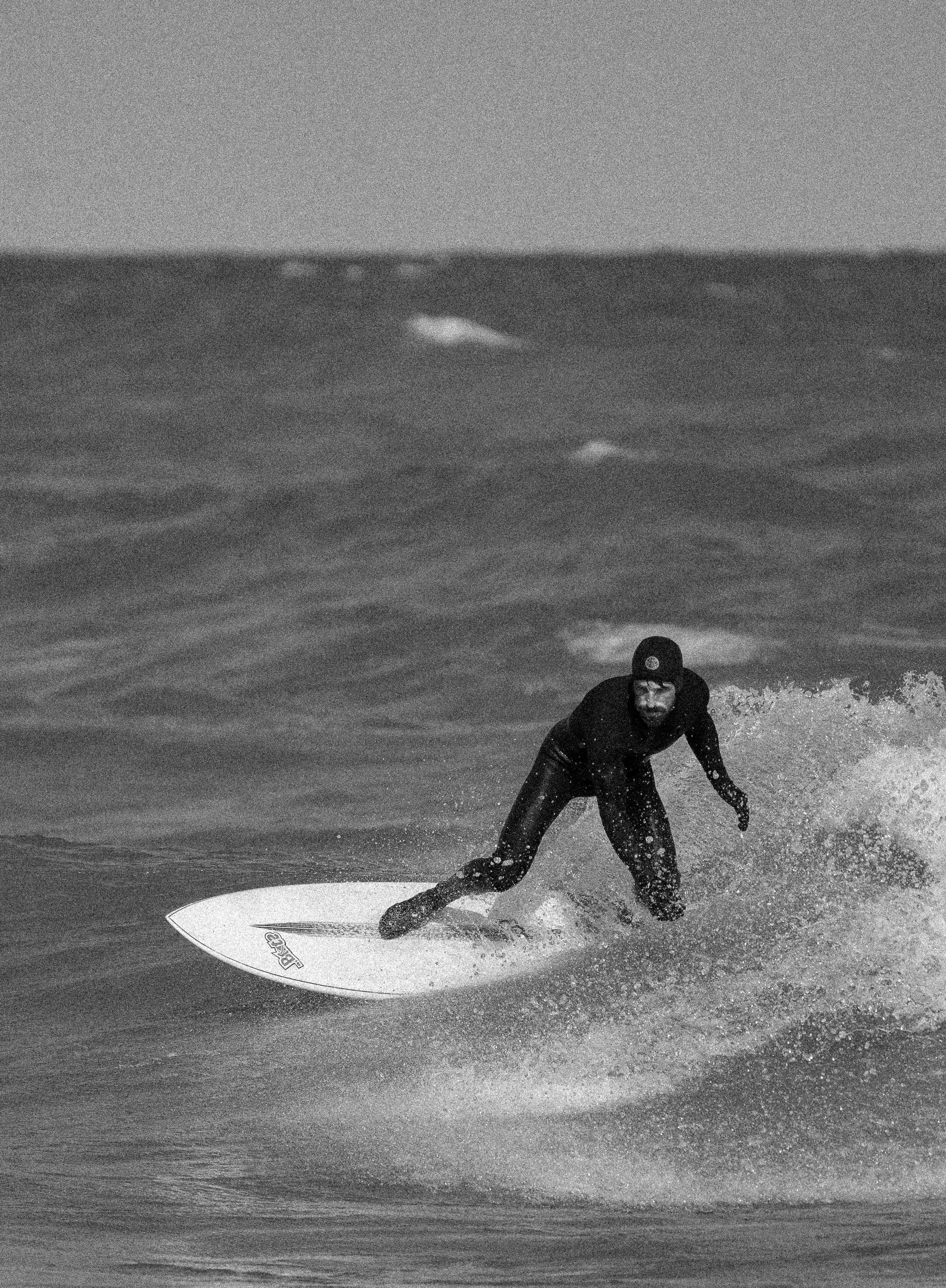 Person surfing on a wave in black and white