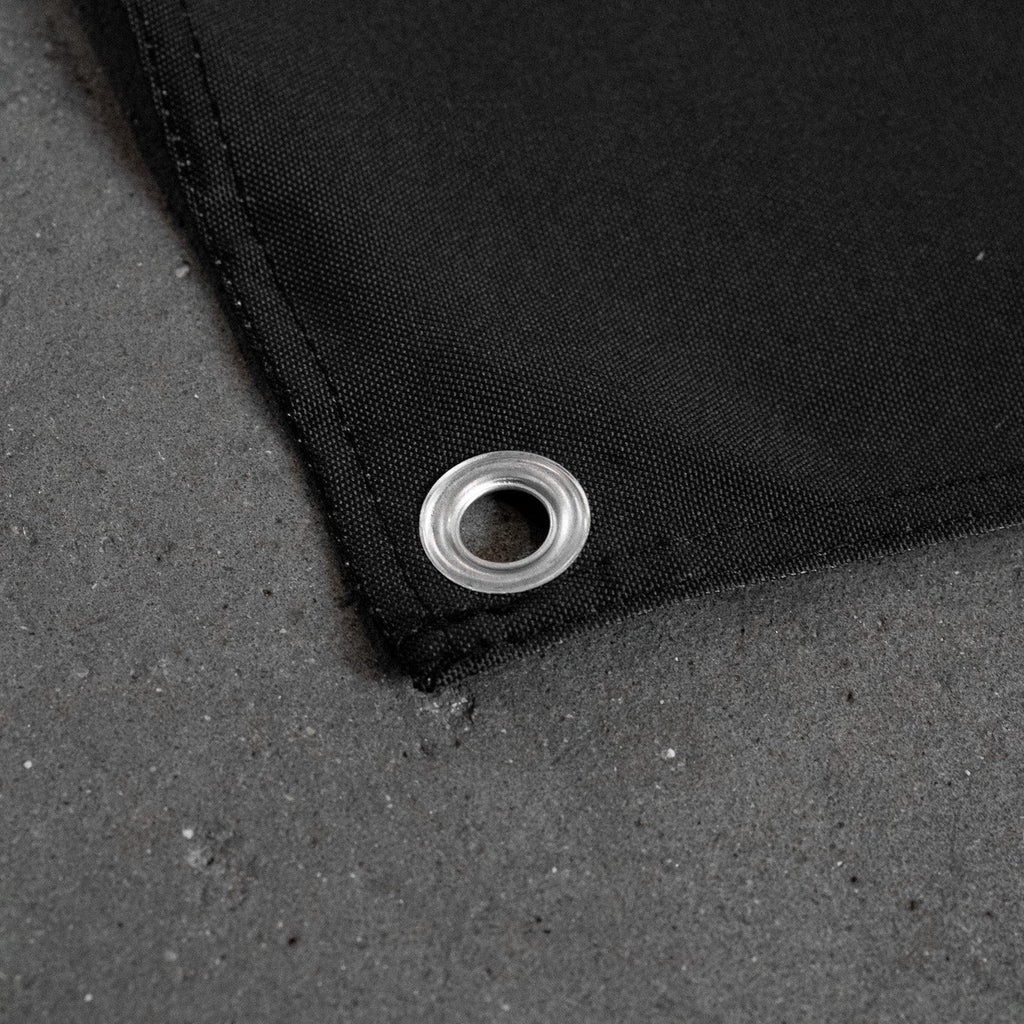 Close up of corner and metal eyelet of a Black banner concrete floor.