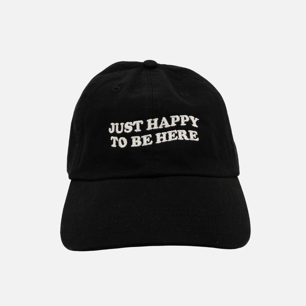 Black dad hat with 'Just Happy to be Here' text on a light gray background