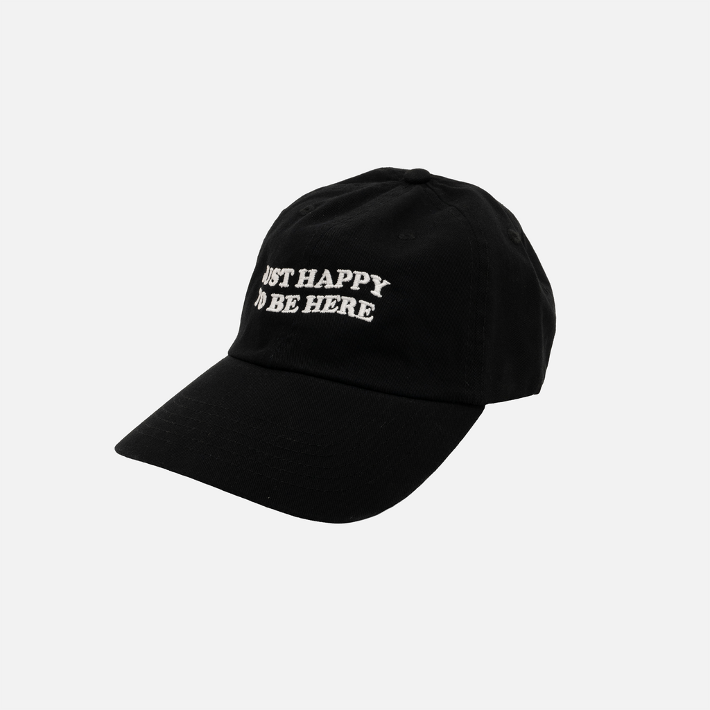 Black dad hat with 'Just Happy to be Here' text on a light gray background