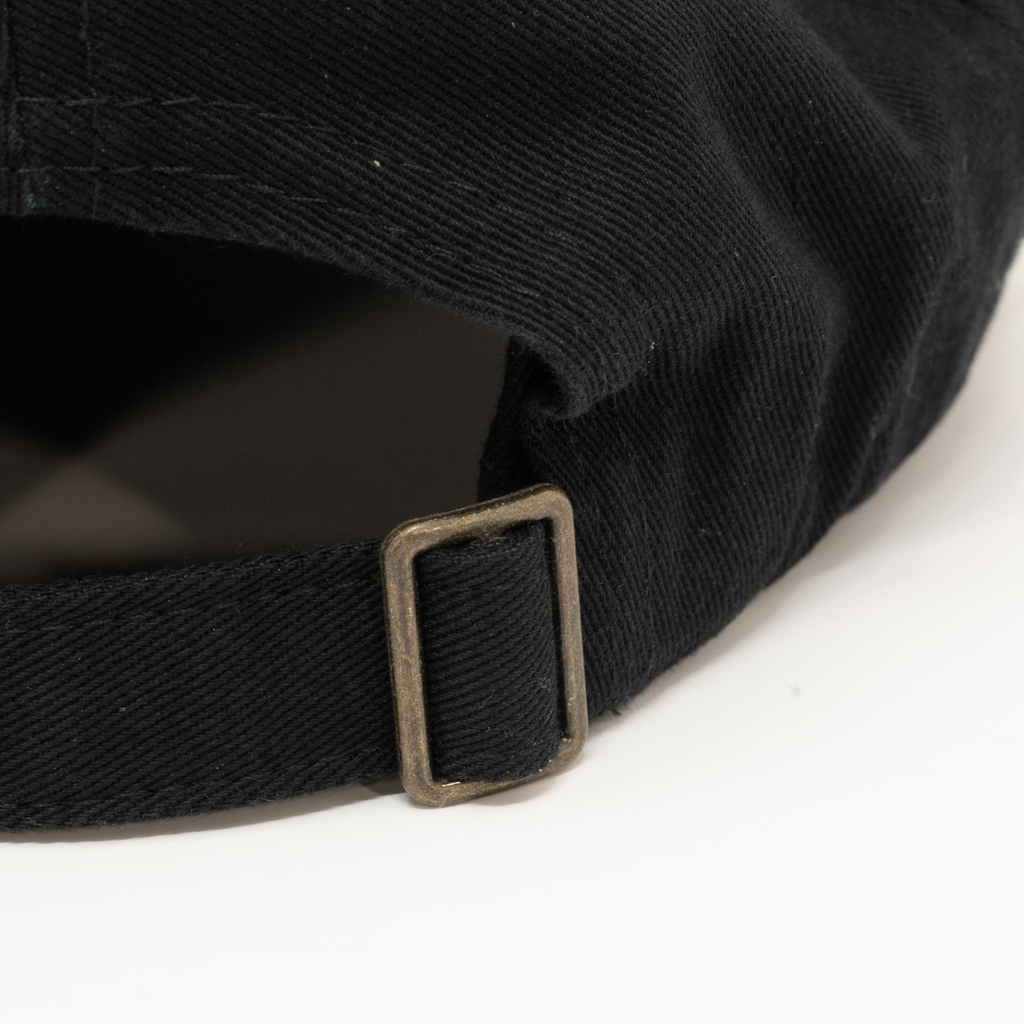 close up of metal buckle on Black hat on a white background