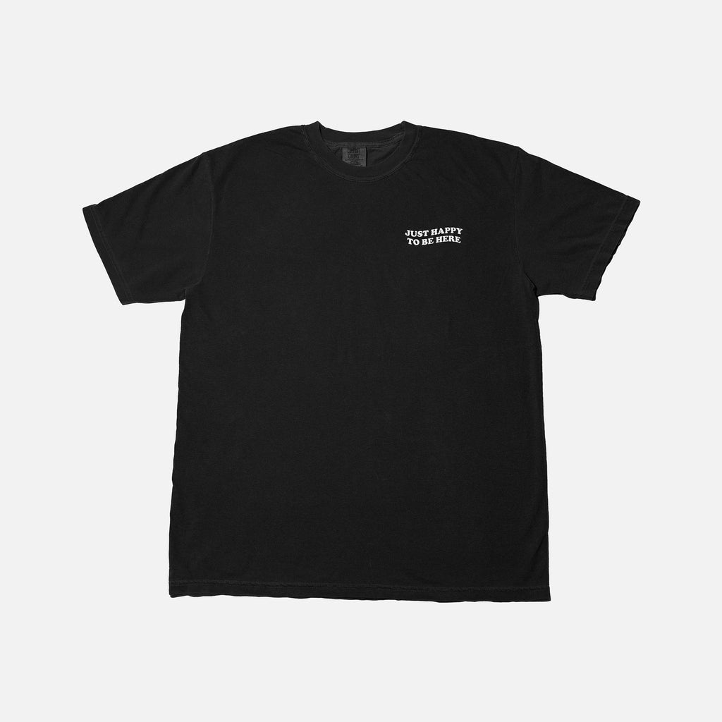 Black t-shirt with white Just Happy To Be Here logo on a light gray background